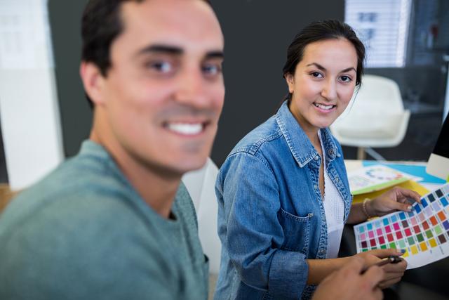 Portrait of male and female graphic designers smiling in office