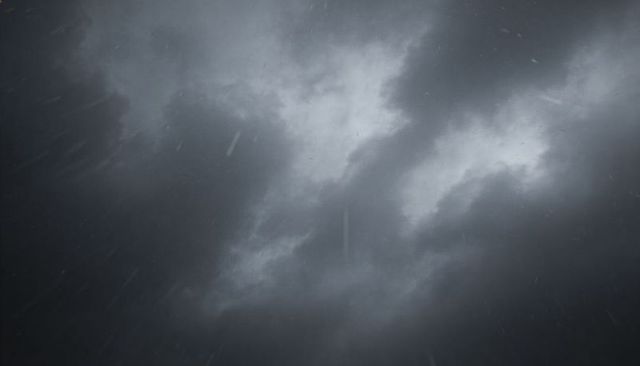 Moody storm sky with dark cloud formations and diagonal rain streaks for dramatic backdrops