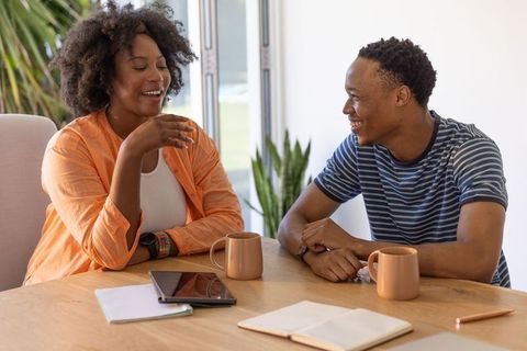African american couple sharing warm conversation over coffee at home sunlit dining table