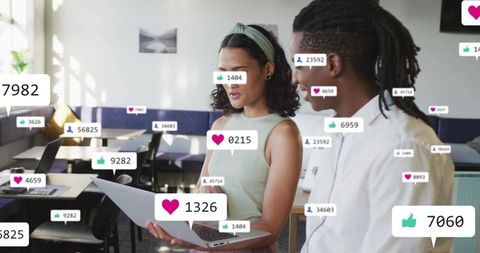Team reviewing social media engagement with floating reaction icons in modern workspace