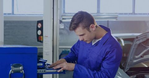 Mechanic Adjusting Equipment in Auto Repair Garage