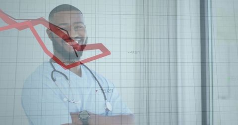 Doctor smiling with stethoscope behind red declining chart in clinic