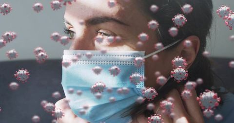 Adjusting surgical mask while virus particles surrounding woman, infection prevention