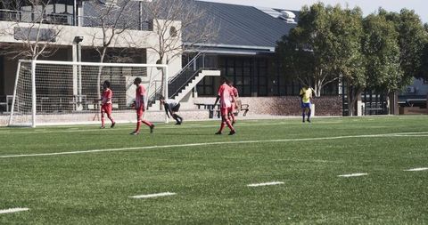 Soccer Players Competing in Outdoor Game on Green Field