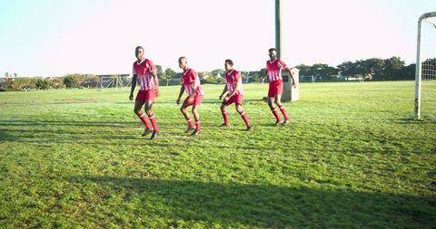 Team of Soccer Players Defending Goal on Field