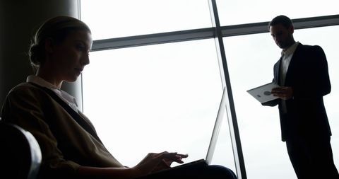 Business Professionals Engaged in Digital Work at Airport