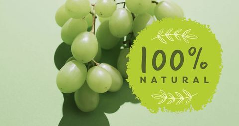 100 percent natural grapes on green background