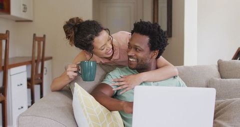 Couple Relaxing at Home with Laptop and Coffee