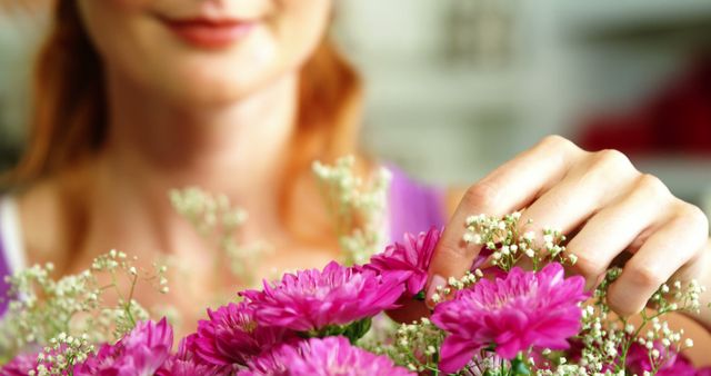 Close-up of female florist arraigning flower bouquet in flower shop