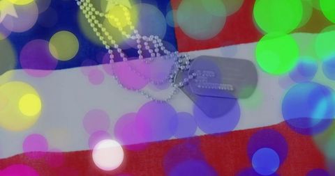 Military Dog Tags on American Flag with Colorful Bokeh Lights