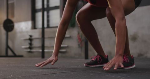 Focused Athlete Crouching at Gym for Sprint Start
