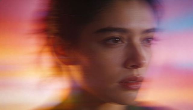 Cinematic closeup of contemplative woman with gel lighting and horizontal motion streaks