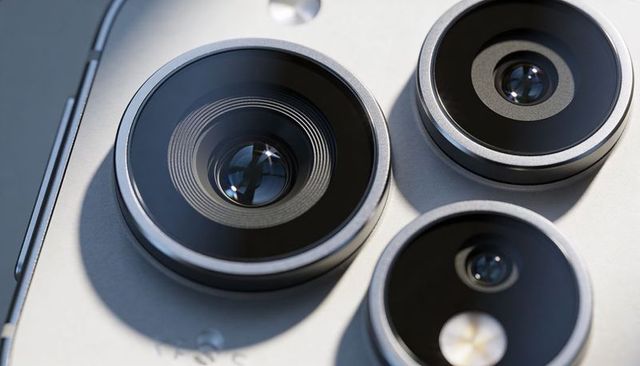Smartphone triple camera close-up showing metal bezels lens rings and optical detail for tech
