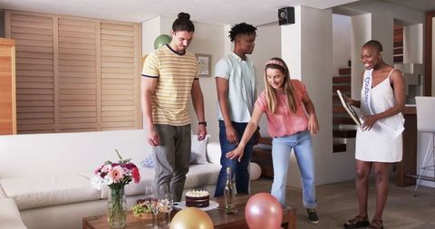 Friends Celebrating at Home with Cake and Balloons