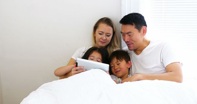 Happy Mixed-Race Family Enjoying Tablet Together in Bed - Download Free Stock Images Pikwizard.com