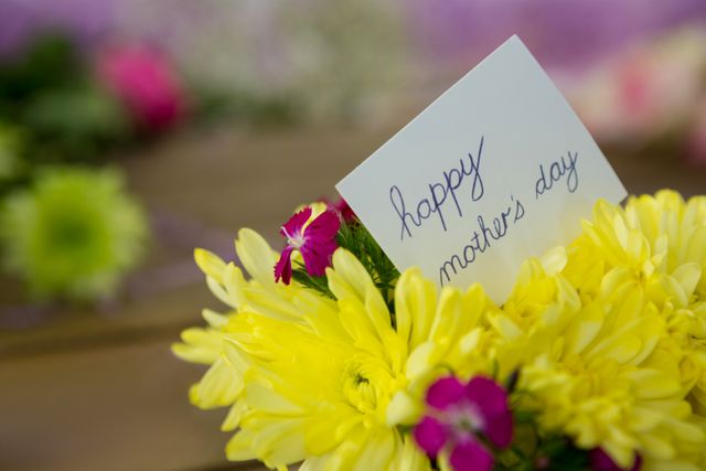 Close-up of happy mother day card on flowers