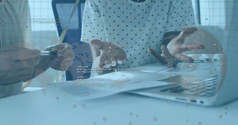 Collaborating on global data analytics and strategy with digital map overlay and laptop