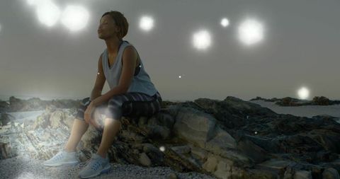 Peaceful Reflection with Glowing Orbs on Rocky Coastline