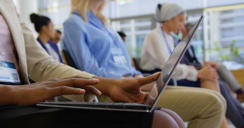 Businesswoman typing on laptop during seminar in modern conference room