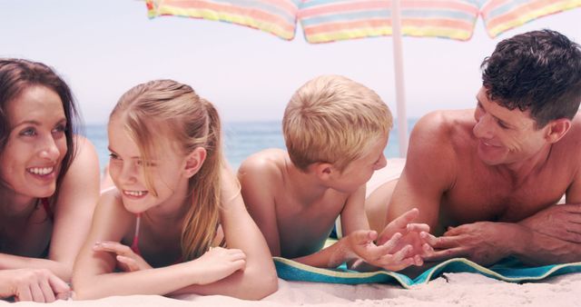 Family Relaxing on Beach Under Colorful Umbrella Smiling - Download Free Stock Images Pikwizard.com