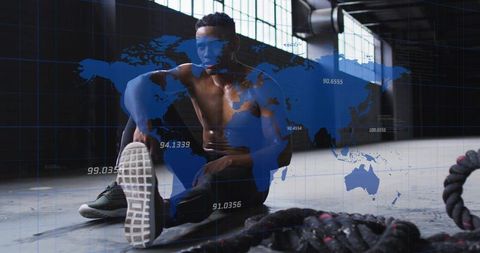 Muscular athlete stretching in industrial gym with battle ropes and digital world hud