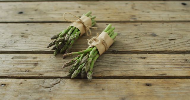 Image of two fresh asparagus bundles on wooden background. fusion food, fresh vegetables and healthy eating concept.
