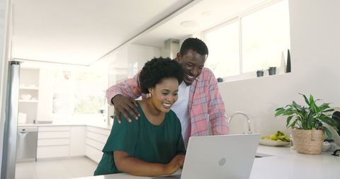 Happy African American Couple Connecting Online in Modern Kitchen