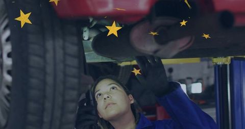 Female mechanic conducting exhaust inspection under lifted car