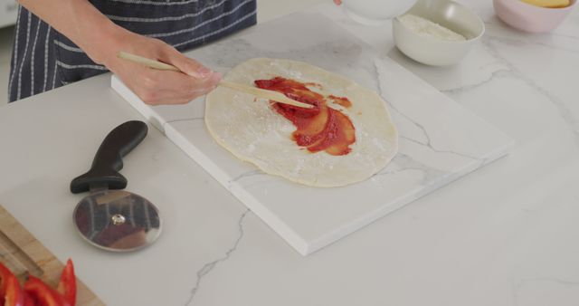 Person Spreading Sauce on Pizza Dough in Kitchen - Download Free Stock Images Pikwizard.com