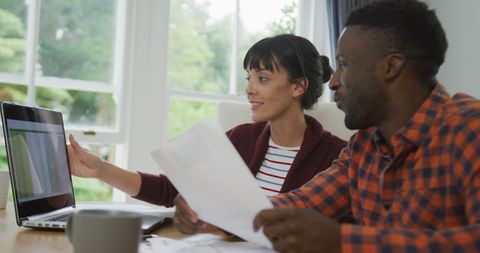 Diverse Couple Collaborating on Laptop in Bright Home