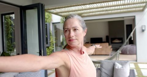 Mature Woman Practicing Yoga on Outdoor Balcony