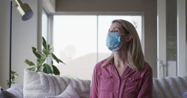 Woman Wearing Mask Sitting on Couch at Home Bright Daylight - Download Free Stock Images Pikwizard.com