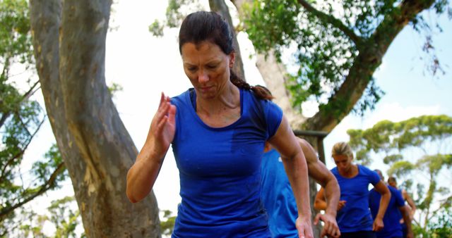 Woman Running Outdoors in Blue Shirt During Group Fitness Class - Download Free Stock Images Pikwizard.com