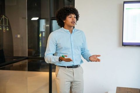 Young Professional Presenting Data in Modern Office Meeting Room