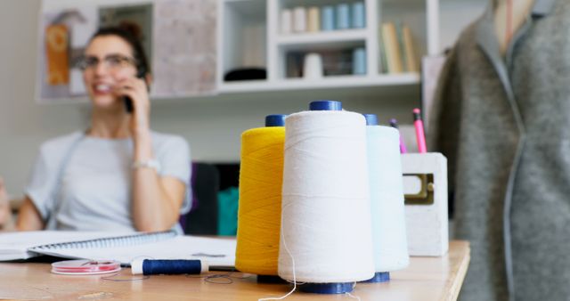 Female Fashion Designer Working in Studio with Thread Spools on Desk - Download Free Stock Images Pikwizard.com