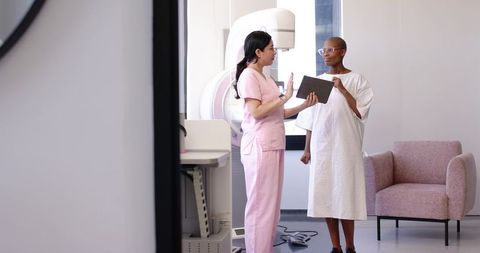 Nurse Explaining Mammogram Procedure to Patient Using Tablet in Radiology Clinic