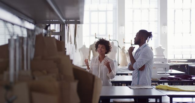 Fashion designers discussing new clothing line in design studio - Download Free Stock Images Pikwizard.com