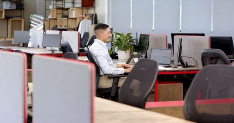 Confident Businessman Working Alone in a Modern Open Office