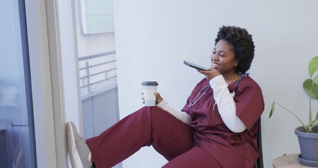 Nurse in Red Scrubs Relaxing and Speaking on Phone with Coffee - Download Free Stock Images Pikwizard.com