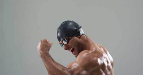 Athlete Celebrating Victory in Swimming Cap and Goggles