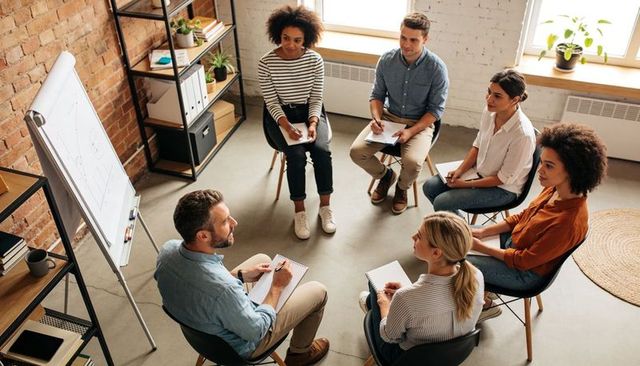 Leading collaborative workshop with colleagues taking notes in modern loft office