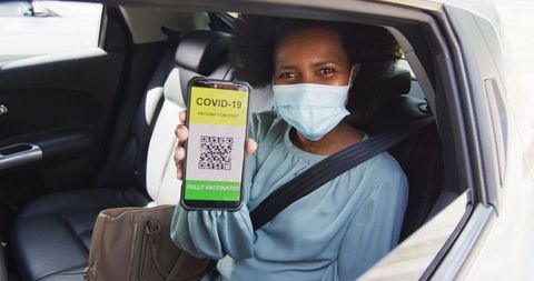 Businesswoman Displaying COVID-19 Vaccine Certification in Car - Download Free Stock Images Pikwizard.com