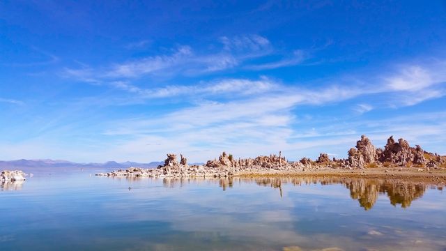 This serene scene of Mono Lake with prominent tufa formations on a calm day is ideal for use in travel brochures, nature and geology educational materials, and websites promoting outdoor activities. Perfect for illustrating the beauty of natural landscapes and promoting environmental awareness.