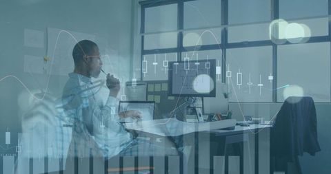 Financial analyst using computer with digital data overlay