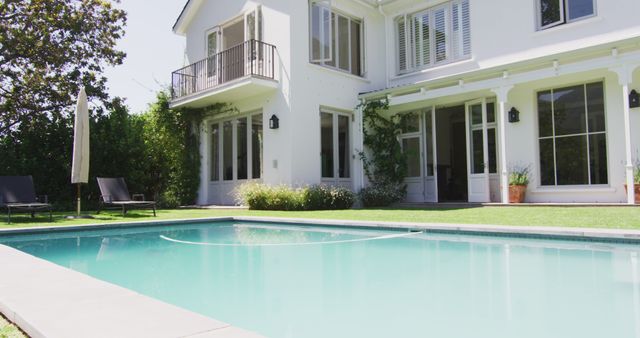 Exterior view of luxury family home and sunny garden with swimming pool - Download Free Stock Photos Pikwizard.com