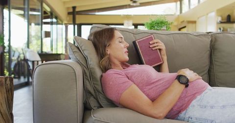 Pregnant Woman Relaxing with Book on Sofa in Cozy Living Room