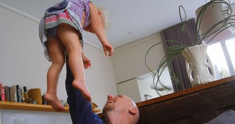 Joyful Father Lifting Daughter Playful Bonding Moment