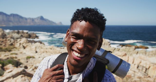 Portrait of african american man exercising outdoors hiking in countryside on a coast. fitness training and healthy outdoor lifestyle.