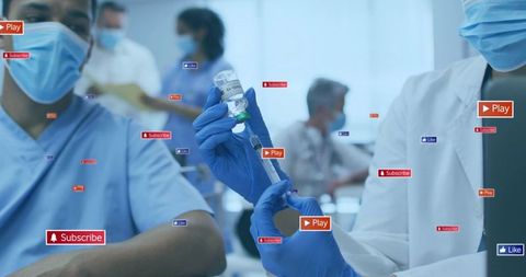 Healthcare team preparing covid-19 vaccine syringe with gloved hands and masked staff