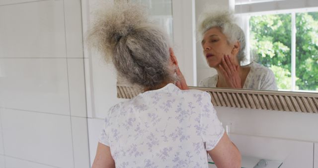 Elderly Woman Checking Skin Condition in Bathroom Mirror - Download Free Stock Images Pikwizard.com